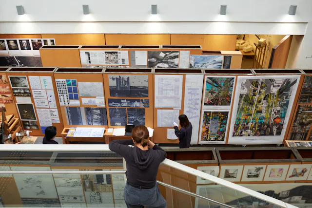 Website 07 Master of Architecture (MArch) - Interior view showing students collaborating on design projects, emphasizing practical teamwork in architecture.